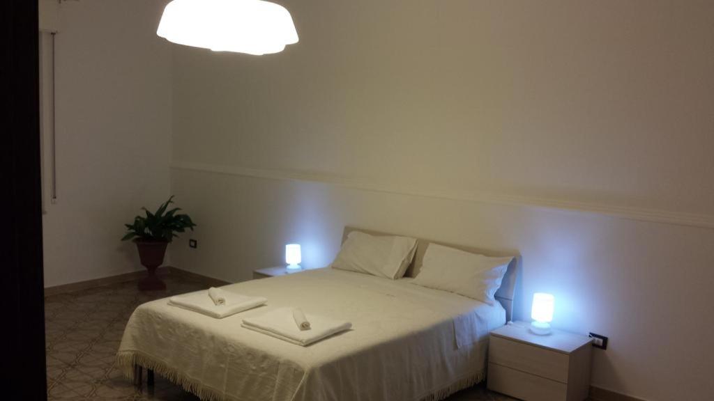 a bedroom with a bed with two candles on it at Peri Peri Holiday Home - Siracusa in Solarino