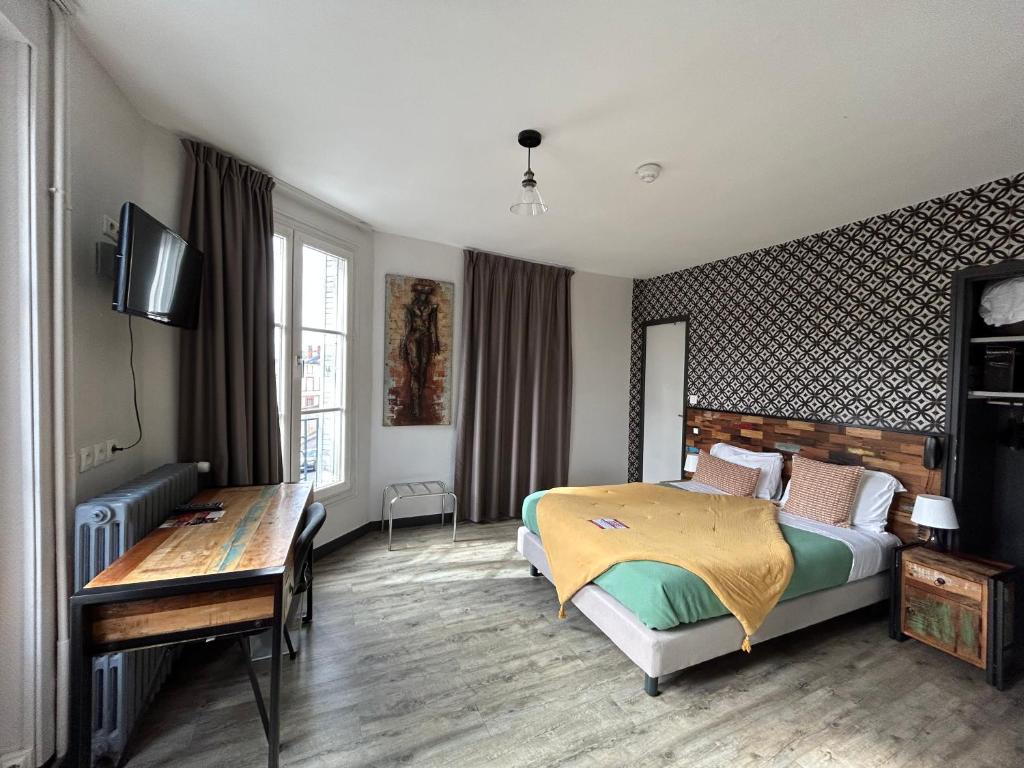 a bedroom with a bed and a table and a television at Le Richelieu Bacchus in Fontainebleau