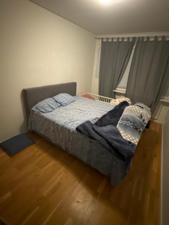 um quarto com uma cama e piso em madeira em Nice room em Borås