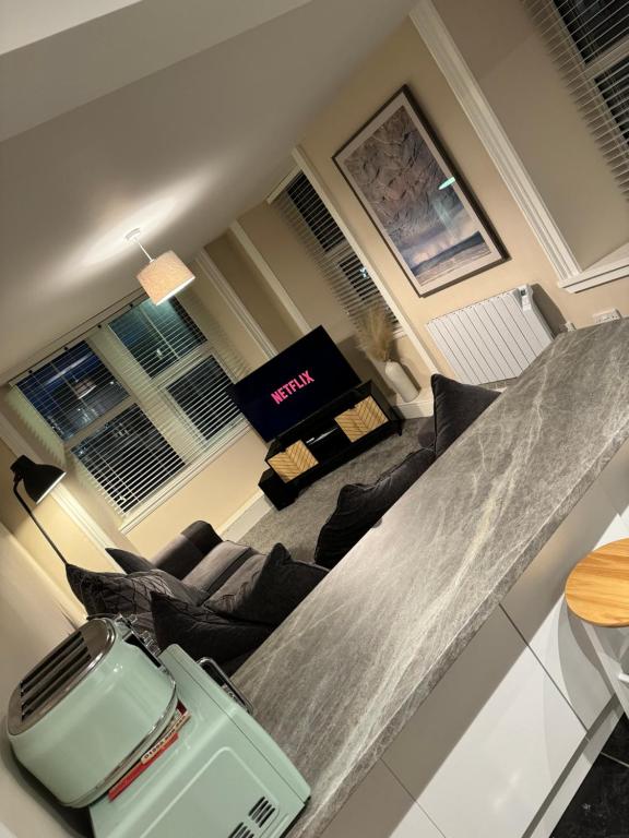 a living room with a couch and a table at Central 2 bedroom apartment in Wick