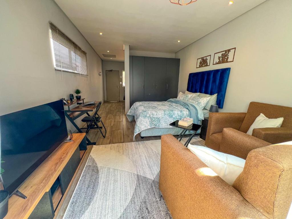sala de estar con sofá y cama en Entire Studio Apartment in Maboneng, en Johannesburgo