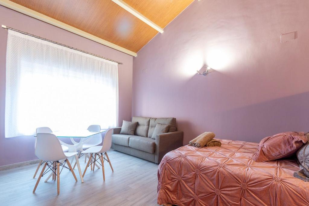 um quarto com uma cama, uma mesa e um sofá em Apartamentos Basílica Santa Eulalia PARKING INCLUIDO em Mérida