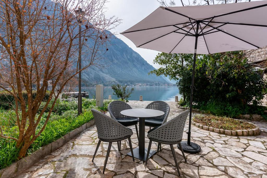 un tavolo con sedie e un ombrellone su un patio di Casa Spada by Belsize a Kotor (Cattaro)