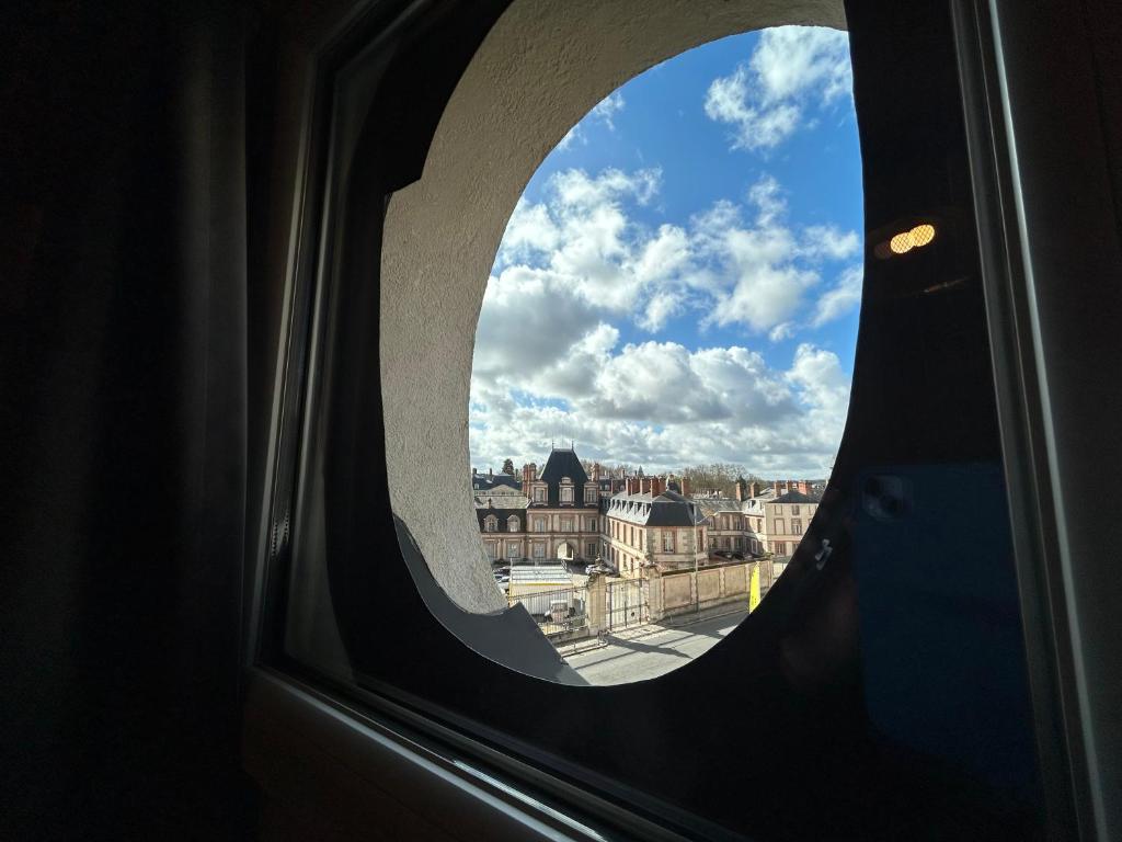 a view of a city from a window at Le Richelieu Bacchus in Fontainebleau