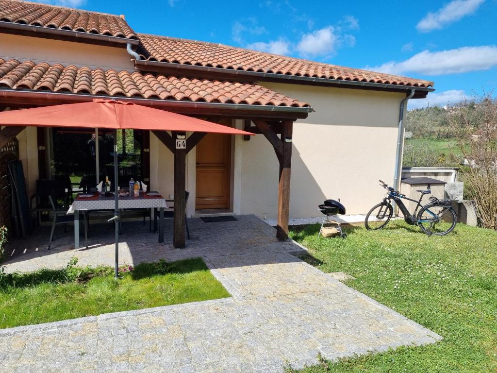een patio met een tafel en een parasol voor een huis bij Les Hauts de Sarlat G4 - Clim Piscine Parking WiFi in Sarlat-la-Canéda