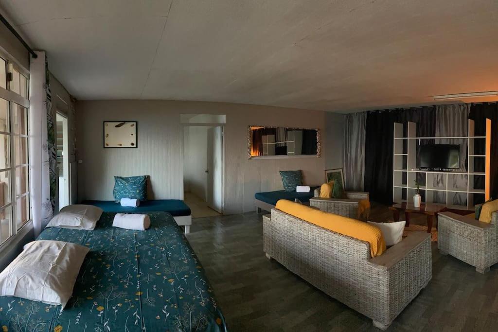 a living room with two beds and a couch at Bienvenue chez Fare Na’i in Fare