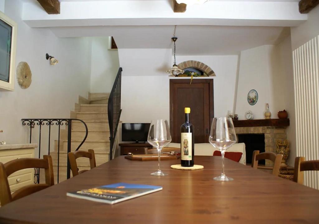 un tavolo con due bicchieri di vino e una bottiglia di vino di Casa La piccola Macina Ripatransone a Ripatransone