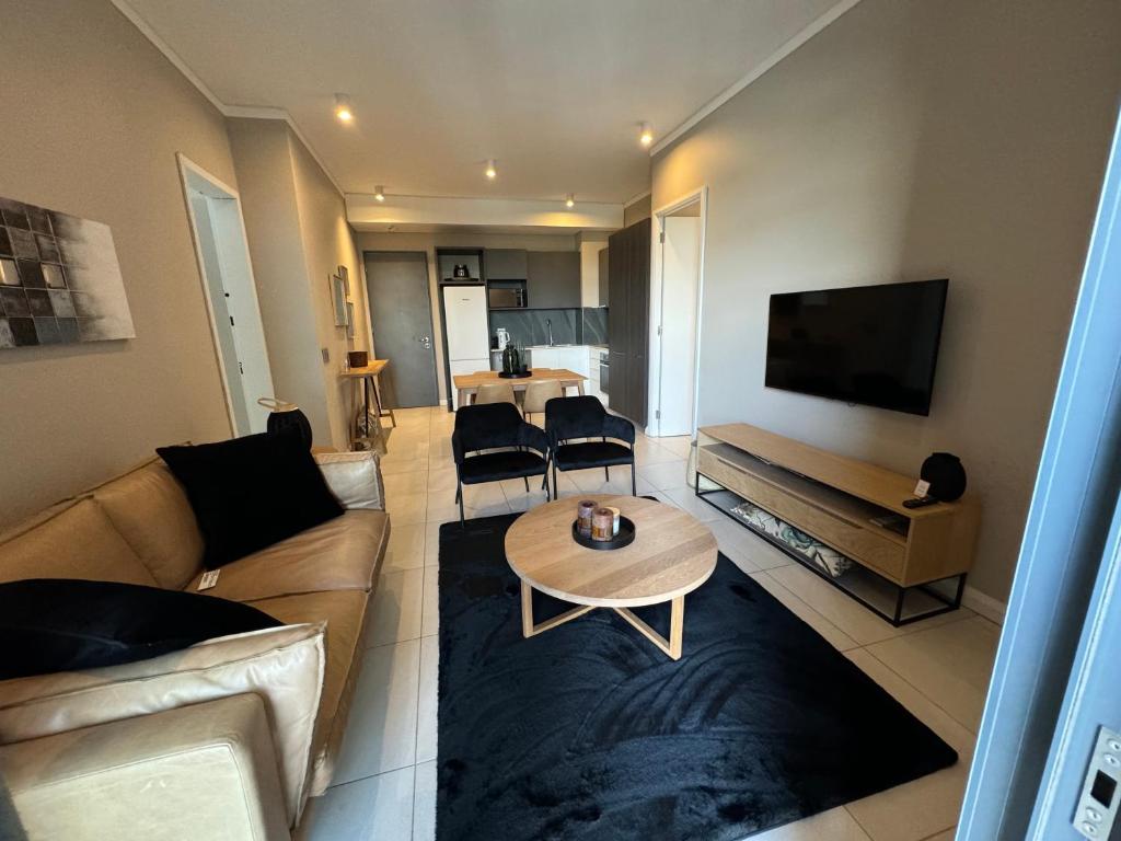 uma sala de estar com um sofá e uma mesa em Menlyn Maine Triology - 10 On Capital em Pretoria