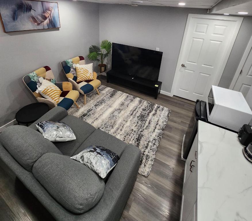 een woonkamer met een bank en een flatscreen-tv bij Entire Basement Suite with Private Entrance in Winnipeg
