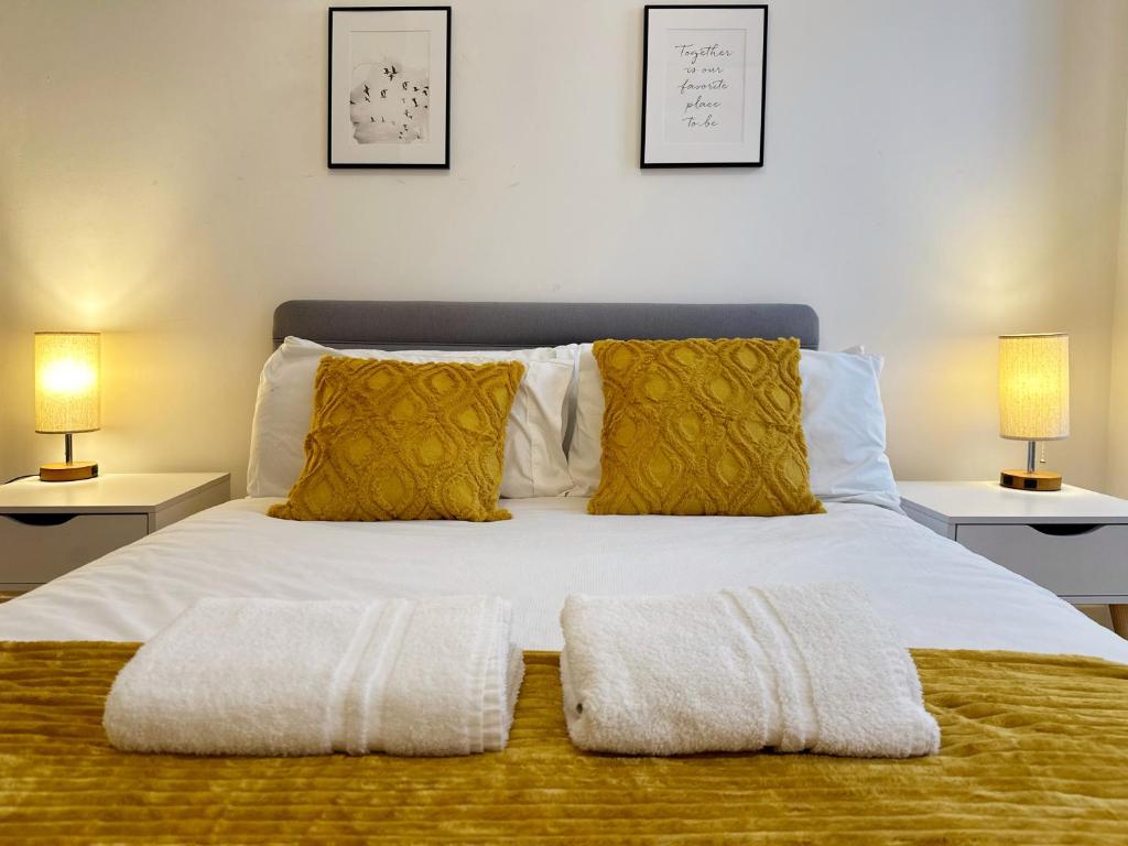 a bedroom with a bed with two lamps on two tables at Rowan’s Place in Holborn in London