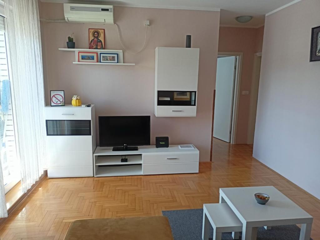un soggiorno con televisore e un centro di intrattenimento bianco di Apartment Andjela a Belgrado