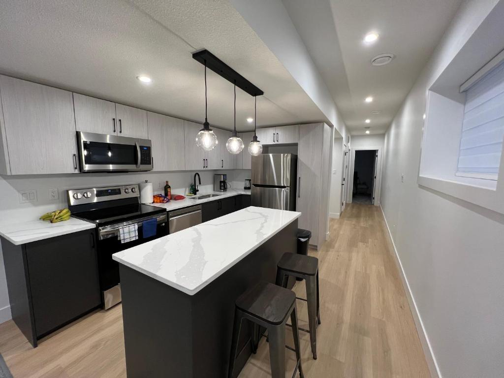 a kitchen with a counter and a stove top oven at NEW Modern and Bright Suite near WEM in Edmonton