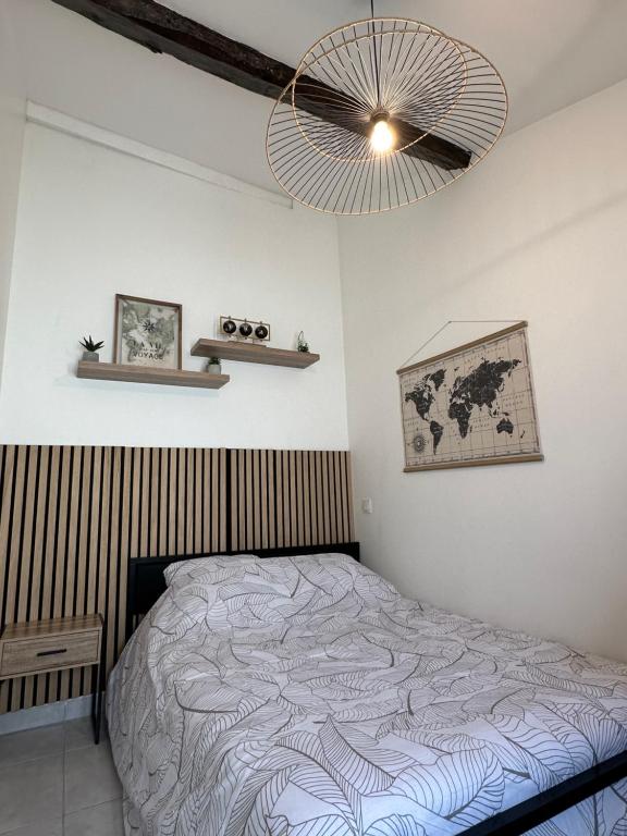 um quarto com uma cama e um lustre em Charmant Duplex en Centre-ville Proche du Puy-du-fouu em Cholet