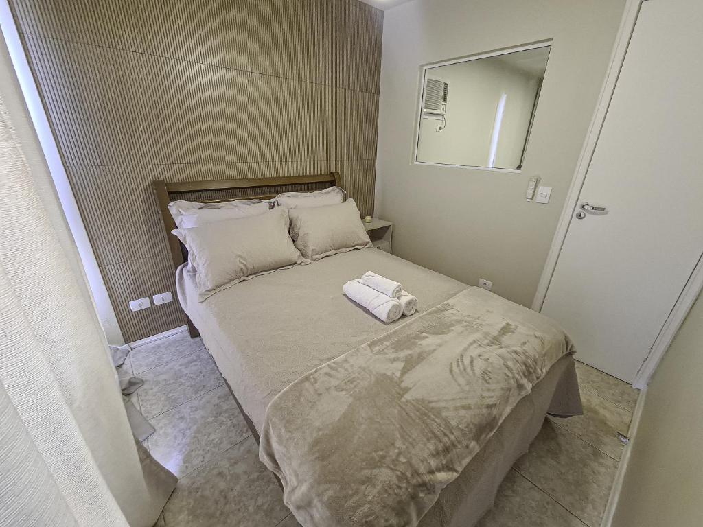 a small bedroom with a bed and a mirror at Studio Central Curitiba in Curitiba