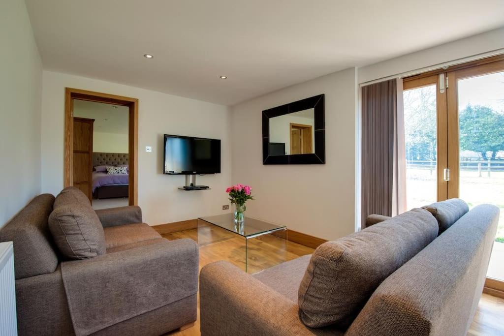 a living room with two couches and a tv at Bramble, luxury in idyllic setting, at Hollambys in Groombridge