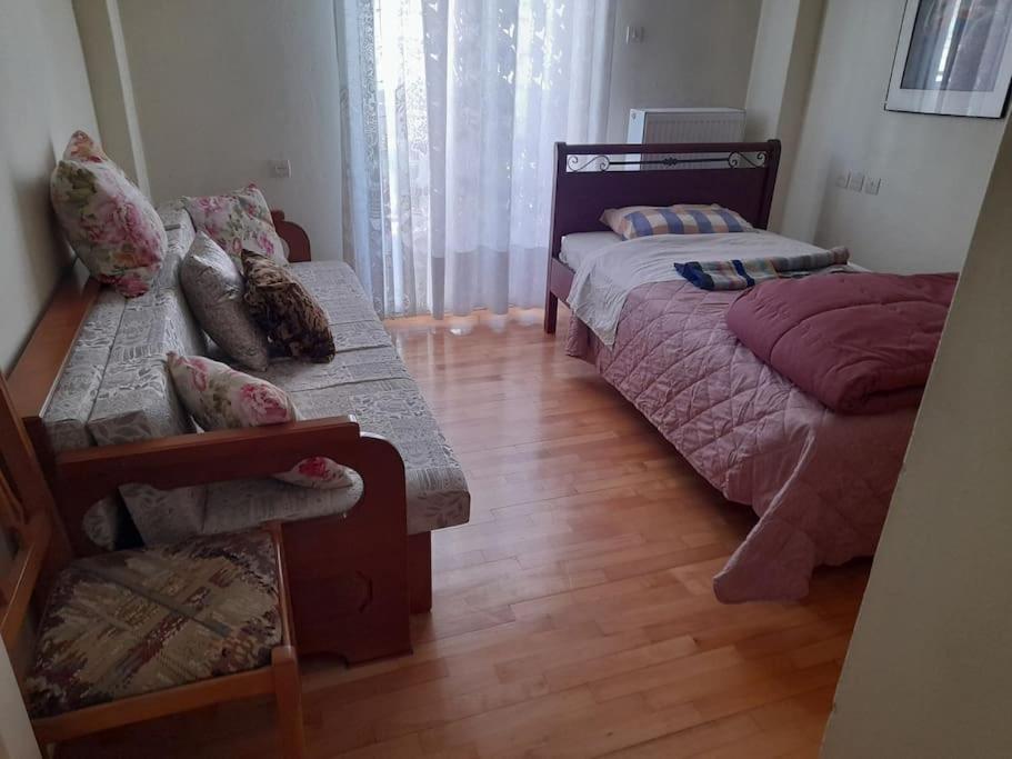 um quarto com 2 camas, um sofá e uma mesa em Ευρύχωρο και άνετο διαμέρισμα em Lárissa