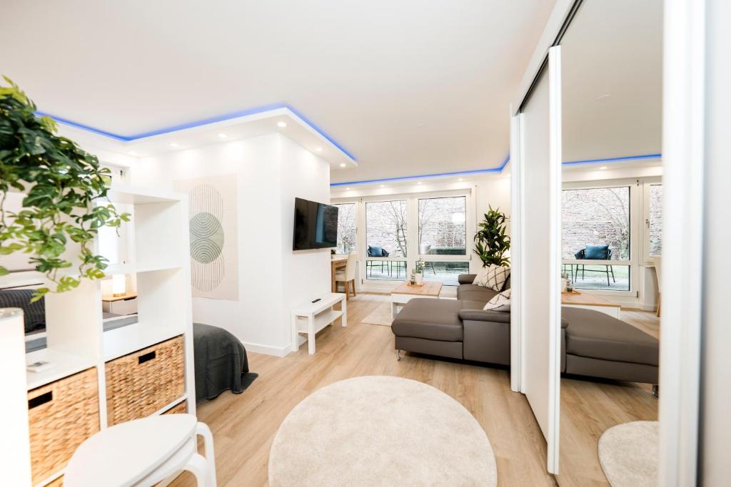 ein Wohnzimmer mit einem Sofa und einem TV in der Unterkunft BellaBene modernes Studio Apartment in toller Lage mit Terrasse, Parkplatz, SmartTV in Pforzheim