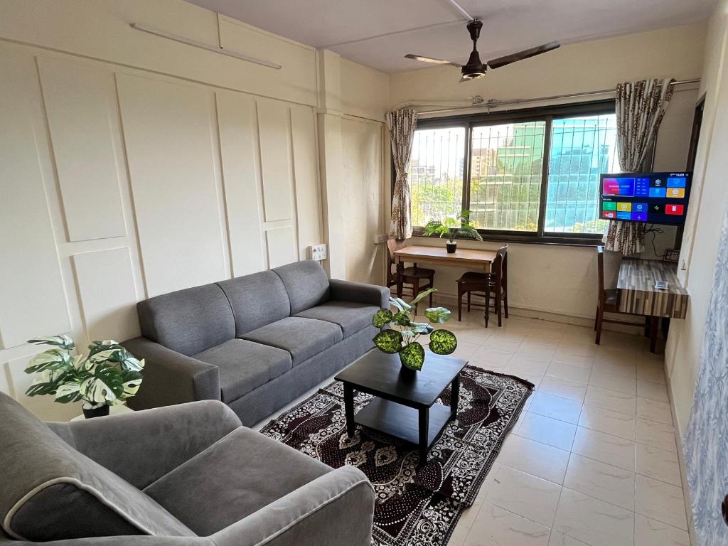 孟買的住宿－Classy & Cozy 1BHK @ Ville Parle Mumbai，客厅配有沙发和桌子