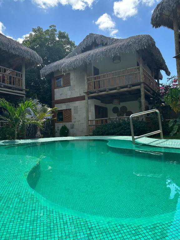 a swimming pool in front of a house at Vila Tamarindo (Bangalô 6) in Barra Grande