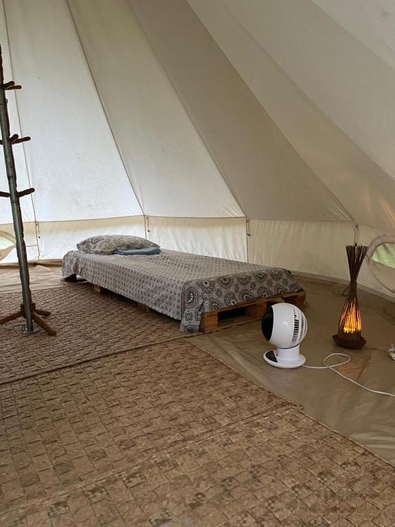 a tent with a bed and a heater in a room at Glamping Bio-Dorf Cabana 1 in Trairi