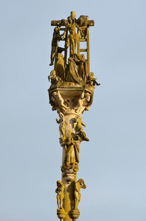 a golden statue of people on a column at Doade in Hio