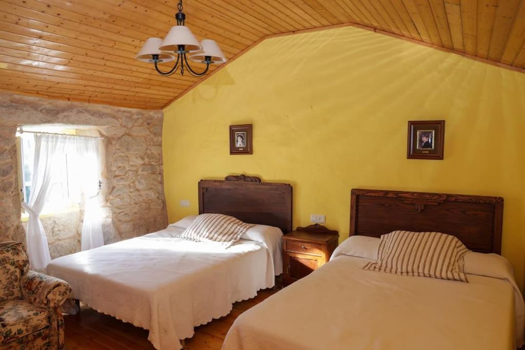 1 Schlafzimmer mit 2 Betten und einem Fenster in der Unterkunft Casa en ruta de los faros costa da morte in Camelle