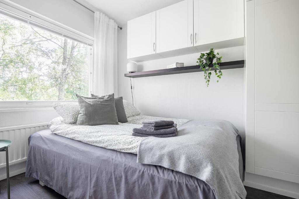 um quarto branco com uma cama e uma janela em Studio Hätilänkatu em Hämeenlinna