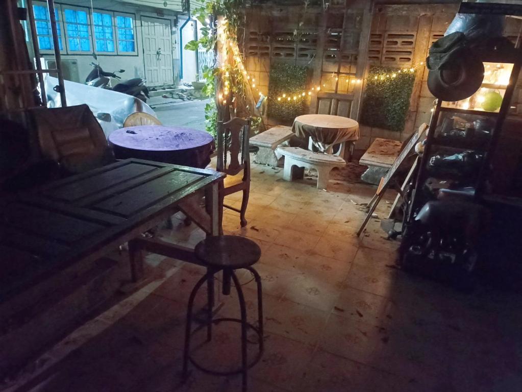Habitación con mesa de madera, sillas y luces. en NP Prime FREE WiFi en Bangkok