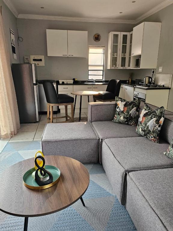 a living room with a couch and a table at Lanina Self Catering Apartments in Johannesburg