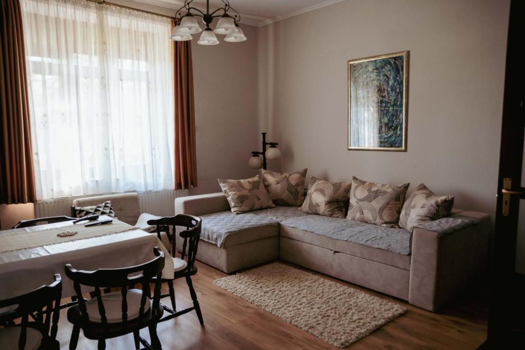 uma sala de estar com um sofá e uma mesa em Dobay Apartman Gyula em Gyula