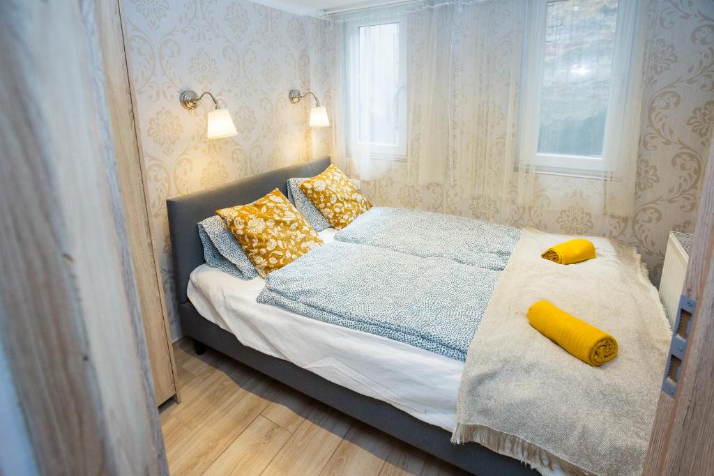 een slaapkamer met een bed met gele kussens bij Memories of Hungary in Boedapest