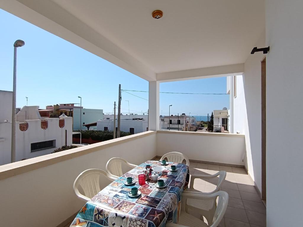 una mesa y sillas en un balcón con vistas en Casa Relax a 200m dal mare, en Lido Marini