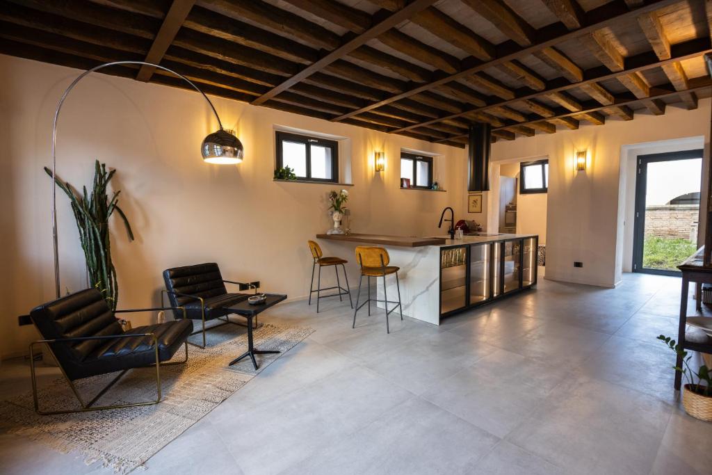 eine Küche und ein Wohnzimmer mit einem Tisch und Stühlen in der Unterkunft Room & Breakfast Civico 07 in Fontanellato