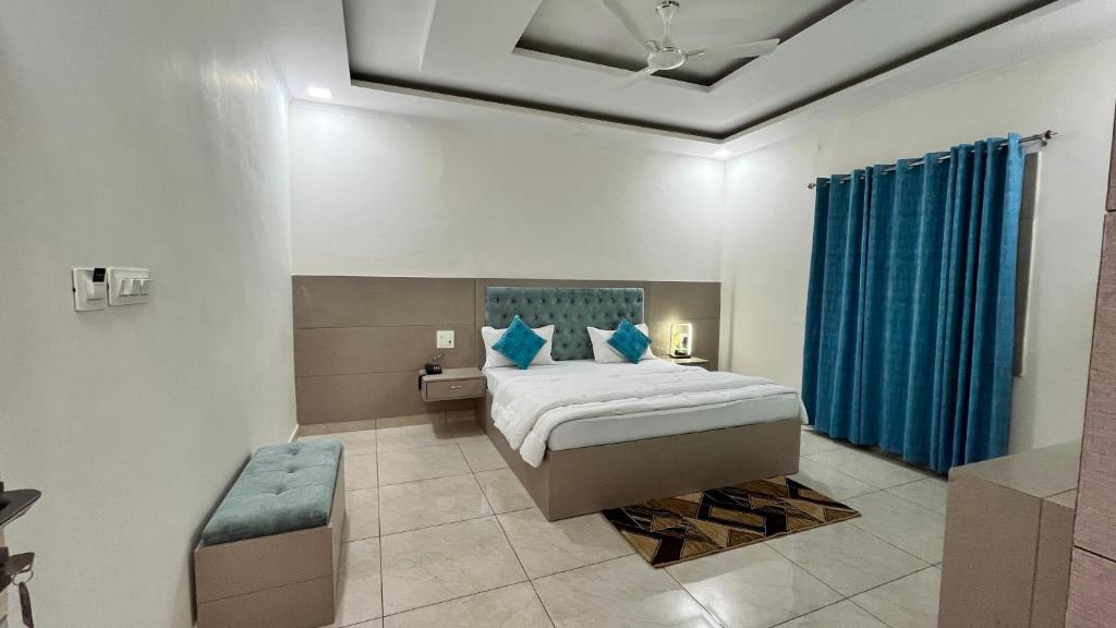 ein Schlafzimmer mit einem Bett und einem blauen Vorhang in der Unterkunft Cosy stay in Haldwani-Kathgodam