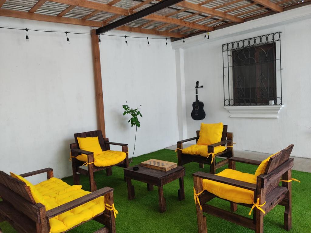 Habitación con sillas, mesa y guitarra en Blue Moon Hostel, en Antigua Guatemala