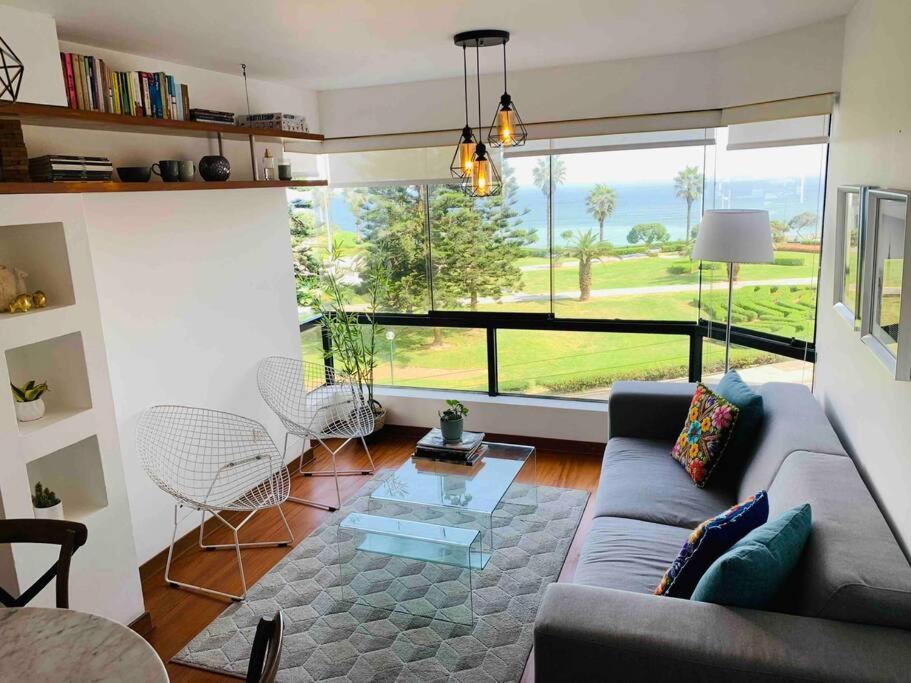 salon z kanapą i dużym oknem w obiekcie Apartamento frente al mar w mieście Lima