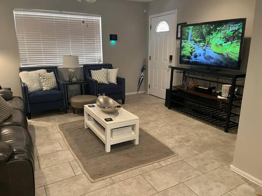 ein Wohnzimmer mit einem Sofa und einem TV in der Unterkunft Sycamore Suite/ Wi-Fi & office in Big Spring