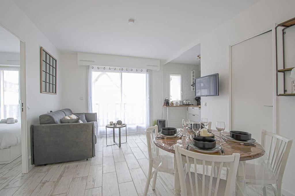 Una cocina y una sala de estar con mesa y sillas. en L'idéal à Blonville, en Blonville-sur-Mer