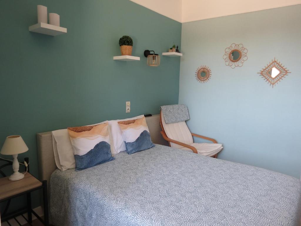 - une chambre avec un lit et une chaise dans l'établissement Hotel Au Petit Béarn, à Salies-de-Béarn