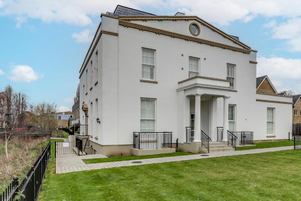 ein weißes Gebäude mit einer Uhr auf der Seite in der Unterkunft Hertfordshire's Luxury House in Hemel Hempstead