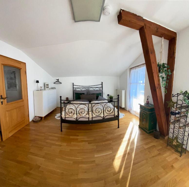 1 dormitorio con 1 cama y suelo de madera en NEUES ruhiges Apartment, Bergblick, Stellplatz, en Bischofswiesen