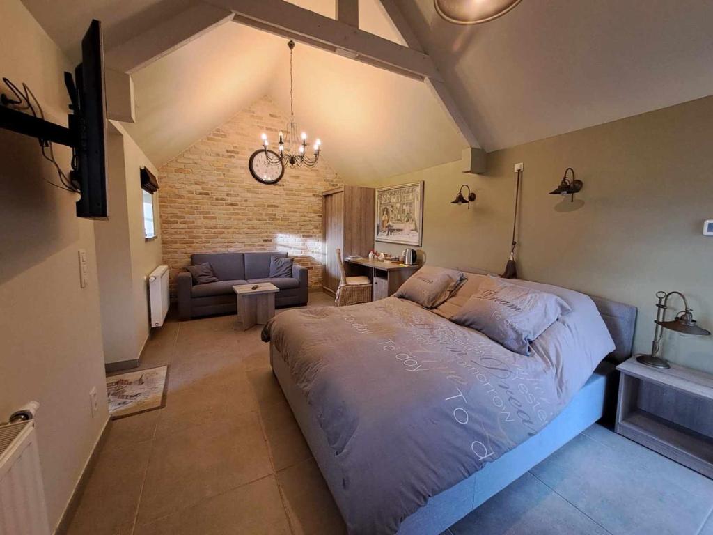a bedroom with a large bed and a living room at B&B 't Hannonshof in Nieuwpoort