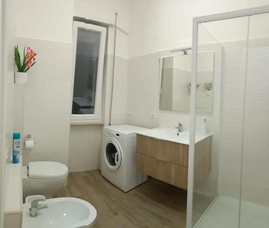 a white bathroom with a washing machine and a sink at Rome Apartment D'Amata in Ciampino