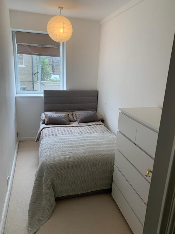 a small bedroom with a bed and a window at Cozy Entire Flat walking to Hyde Park in London