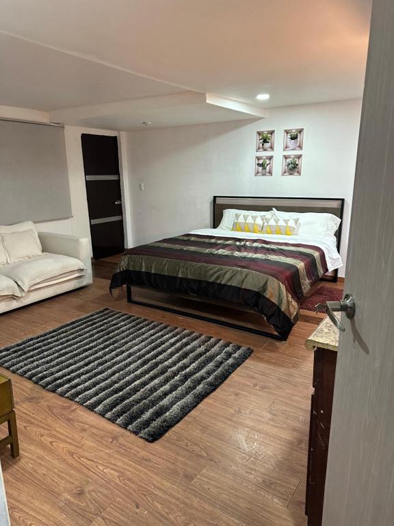a bedroom with a large bed and a couch at Mi Delicioso Escape in San Luis Río Colorado