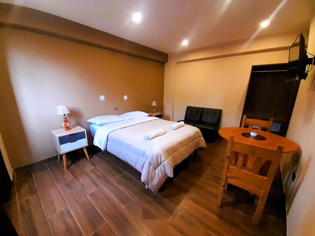 um quarto com uma cama grande e uma mesa em LAGUNA HOUSE em Huaraz