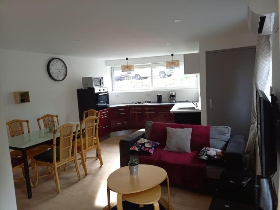 un salon avec un canapé rouge et une table dans l'établissement Appartement Chez Marcel, à Saint-Lager-Bressac