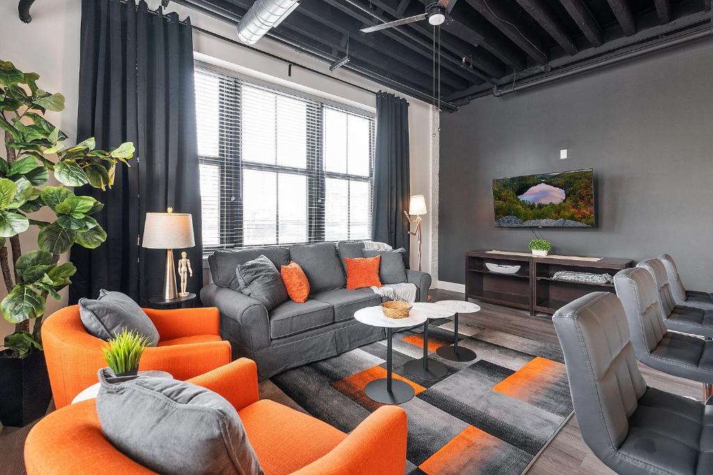 a living room with a couch and orange chairs at Luxury Urban 1BR King Bed-Parking - Heart of Historic Germantown - Temple & LaSalle -105- Stay Long Term! in Philadelphia