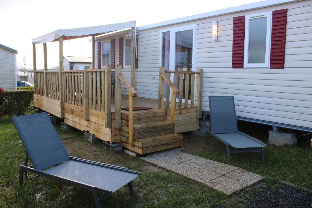 a house with a wooden deck with two chairs at Mobil-home in Litteau