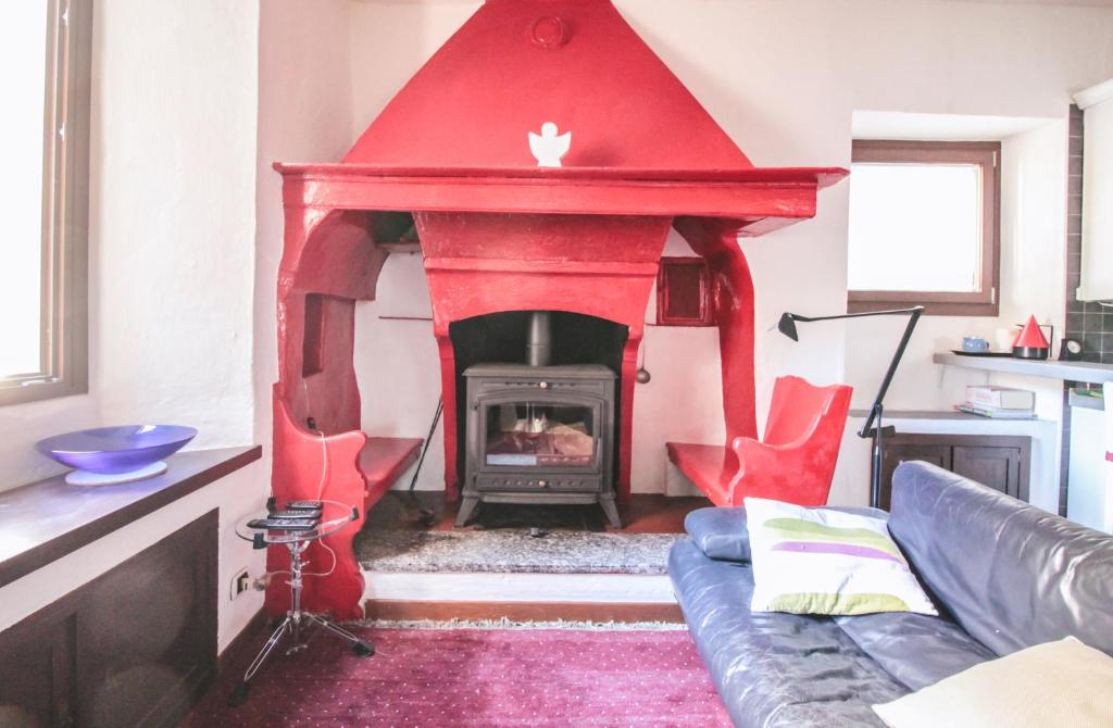 einen roten Kamin im Wohnzimmer mit Sofa in der Unterkunft Casa Annita in Naggio